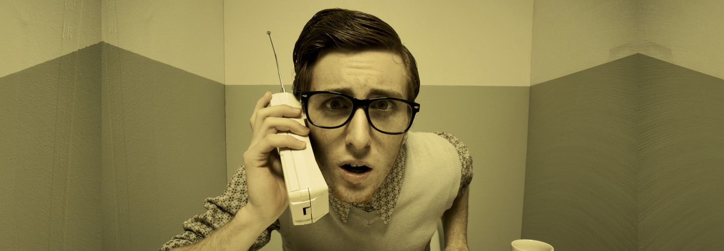 vintage headshot of a person on a handheld phone looking at camera