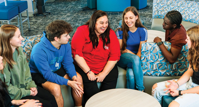 Kerri Wall, Senior Instructional Technology Administrator and Data Privacy Compliance Officer for the School District of Indian River County, works with students in a new collaborative library space.