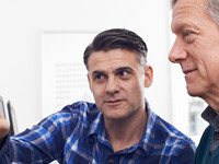 Man helping other teacher on computer