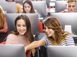 A room of students in front of their computer monitors